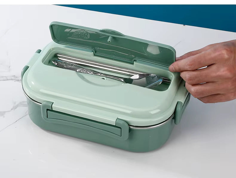 Green lunch box open with tableware